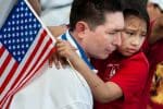 Child Facing Deportation with American Flag, Held by her Father