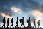 Silhouetted Line of Walking Refugees Seeking Asylum, Sky and Clouds Behind Them