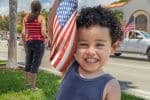 Little latino boy holding an American Flag