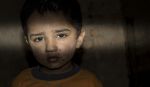 a refugee homeless child standing in a dark room with sad expression